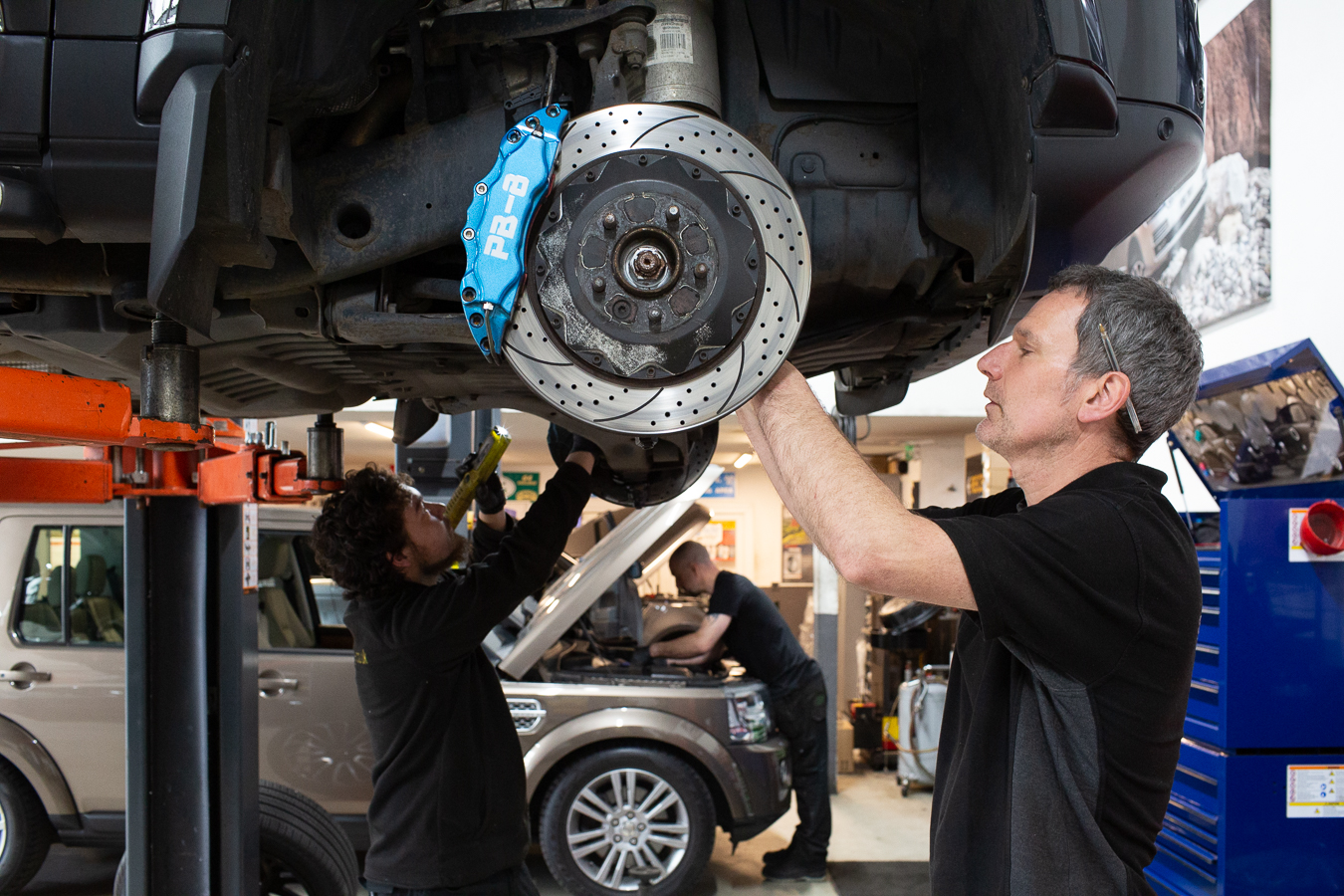 Vehicle on a lift with the wheel off, showing the brake disc